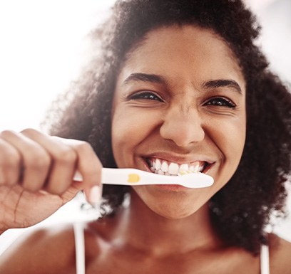 a young woman brushing her teeth