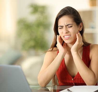 Grimacing woman suffering from TMJ pain