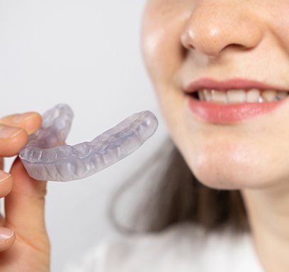 Woman holding occlusal splint close to her mouth