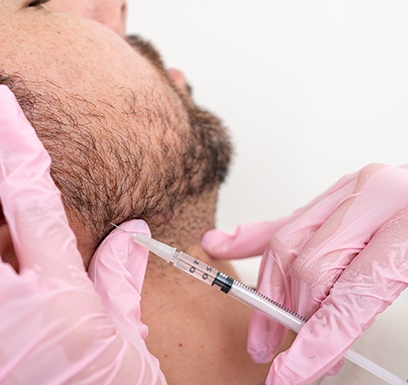 Man receiving BOTOX injection in his jaw