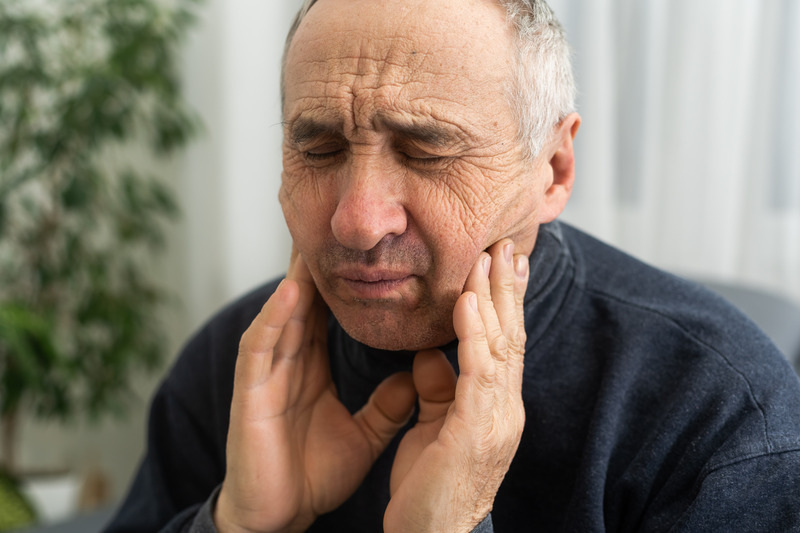 Patient holding their cheek due to a toothache