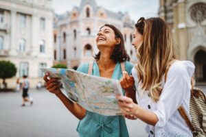 two friends traveling abroad together looking at a map